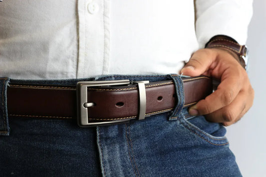a person wearing a leather belt with blue jeans and white shirt